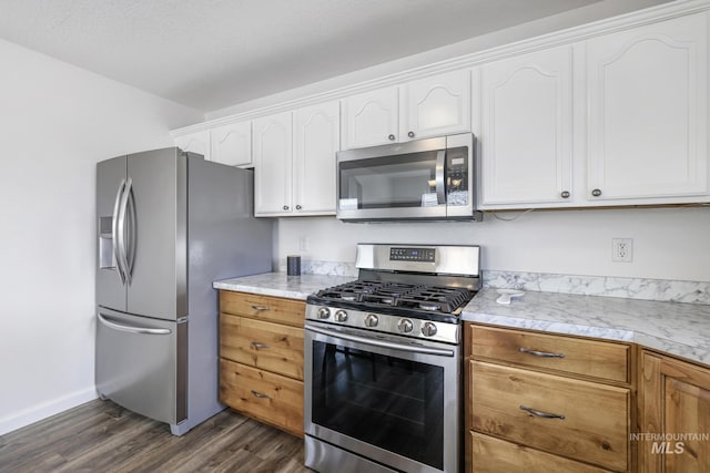 kitchen featuring white cabinets, appliances with stainless steel finishes, light countertops, baseboards, and dark wood-style floors