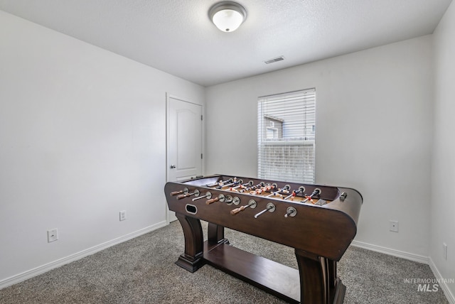rec room with visible vents, baseboards, a textured ceiling, and carpet floors