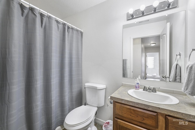 full bathroom featuring toilet, a textured ceiling, and vanity