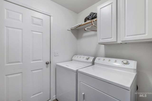 washroom with cabinet space and washer and dryer