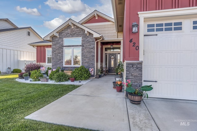 420 Poppy St, Fruitland, ID 83619 - doorway to property featuring stone siding, a yard, board and batten siding, and a garage