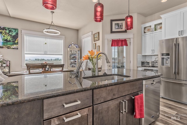 420 Poppy St, Fruitland, ID 83619 - kitchen with stainless steel appliances, a sink, glass insert cabinets, backsplash, and white cabinetry