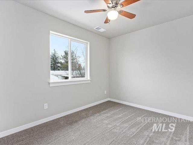 empty room featuring carpet floors, baseboards, visible vents, and ceiling fan