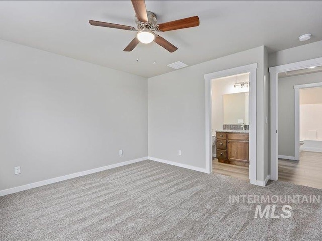 unfurnished bedroom with visible vents, baseboards, connected bathroom, and light colored carpet