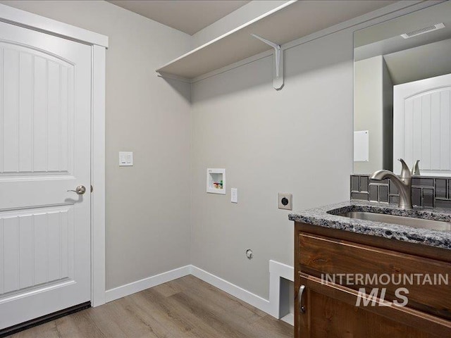 clothes washing area featuring washer hookup, visible vents, hookup for an electric dryer, a sink, and laundry area