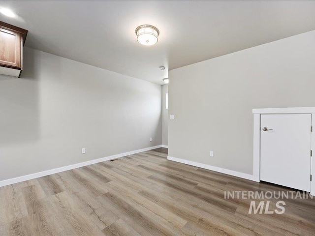 additional living space with light wood-style floors and baseboards