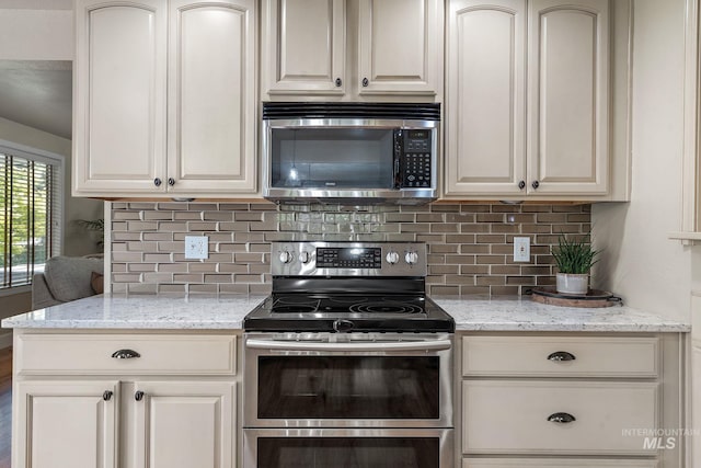 4545 N Columbine St, Boise, ID 83646 - kitchen with appliances with stainless steel finishes, decorative backsplash, light stone counters, and cream cabinetry