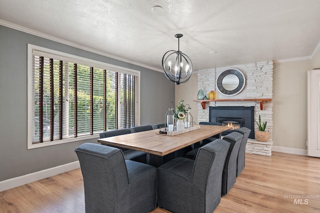 4545 N Columbine St, Boise, ID 83646 - dining room with light wood-style floors, a chandelier, baseboards, crown molding, and a fireplace