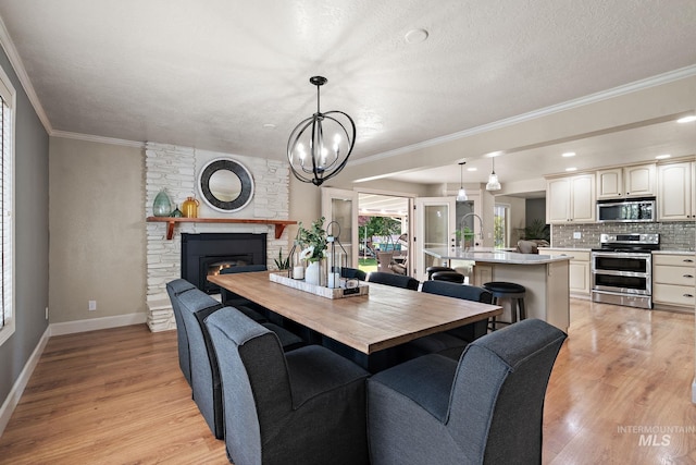 4545 N Columbine St, Boise, ID 83646 - dining room featuring light wood-style flooring, baseboards, crown molding, a fireplace, and a chandelier
