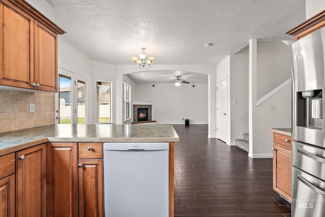 1452 E Pistioa Dr, Meridian, ID 83642 - kitchen with dishwasher, stainless steel refrigerator with ice dispenser, a peninsula, brown cabinets, and a textured ceiling