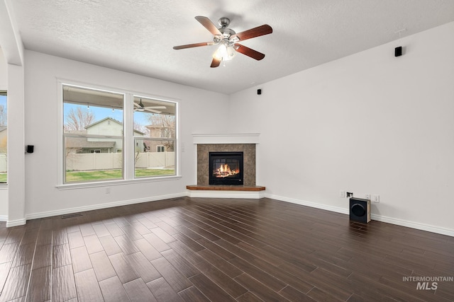 1452 E Pistioa Dr, Meridian, ID 83642 - unfurnished living room with ceiling fan, dark wood finished floors, a tile fireplace, and a textured ceiling