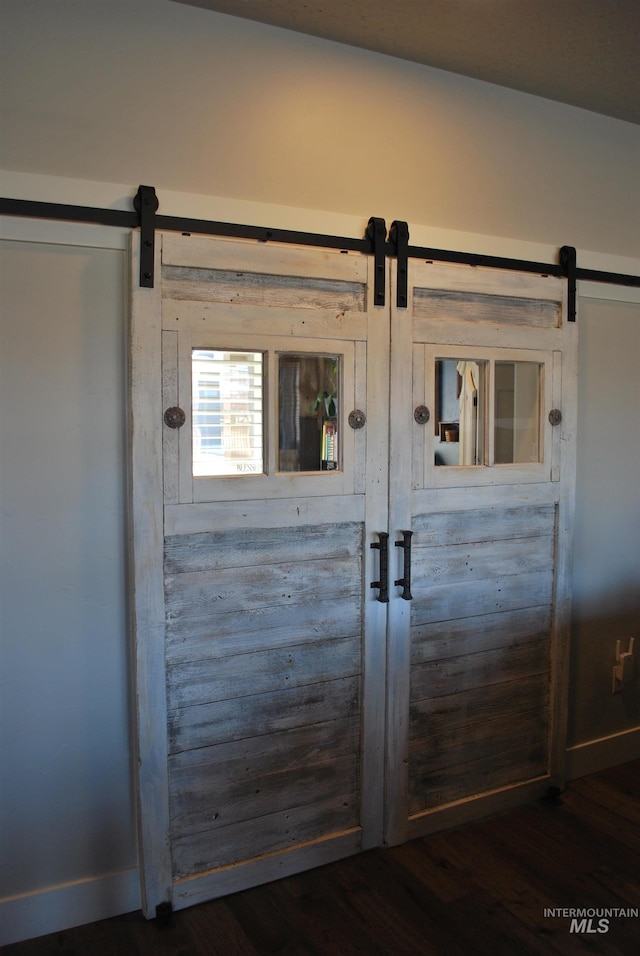 details with a barn door and wood finished floors