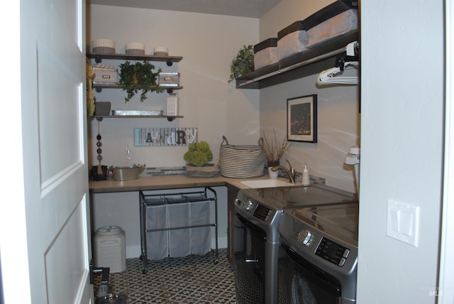 washroom featuring laundry area, washing machine and dryer, and a sink