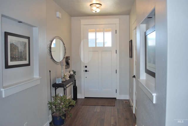 foyer entrance with dark wood finished floors and baseboards