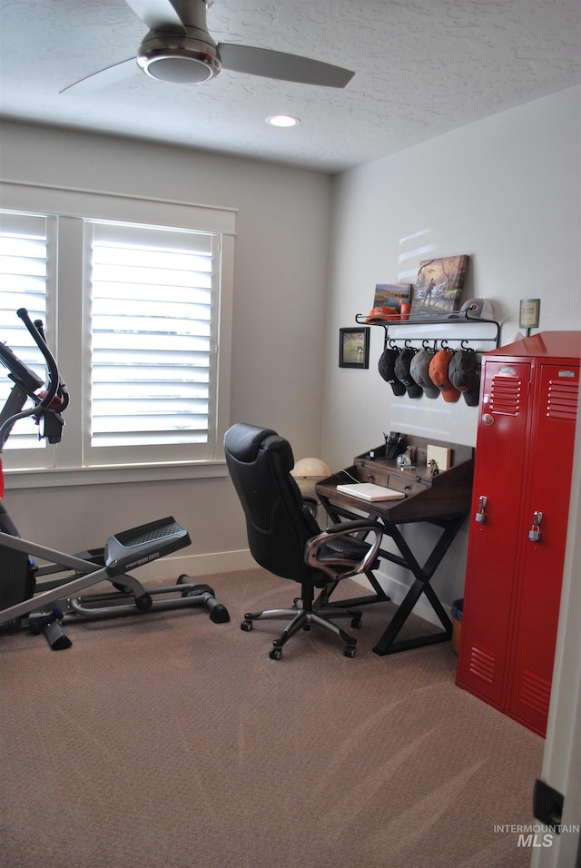 home office featuring baseboards, a textured ceiling, a ceiling fan, and carpet floors