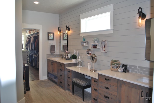 full bath featuring vanity, wood finished floors, baseboards, recessed lighting, and a spacious closet