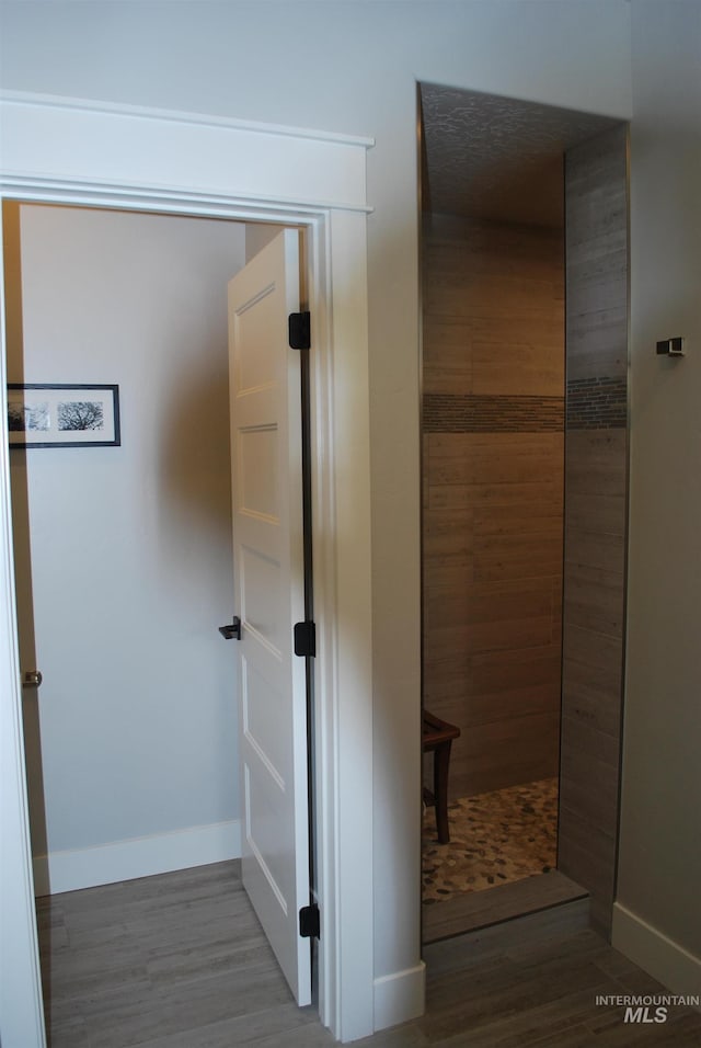 hallway with wood finished floors, baseboards, and a sauna