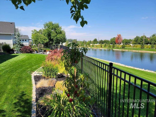 view of yard with a fenced backyard and a water view