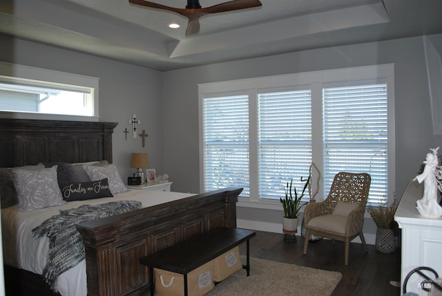 bedroom with recessed lighting, ceiling fan, a tray ceiling, and wood finished floors