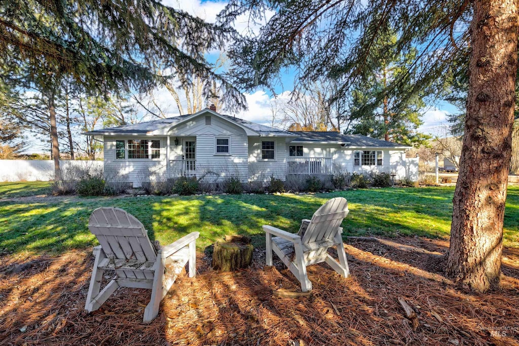 rear view of property featuring a lawn and a chimney