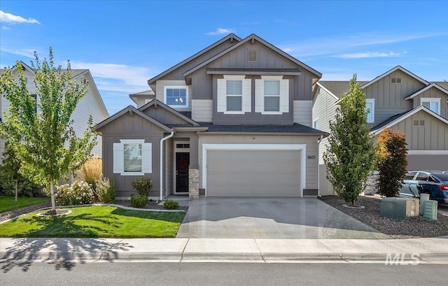 craftsman-style house with a garage, a front yard, board and batten siding, and concrete driveway