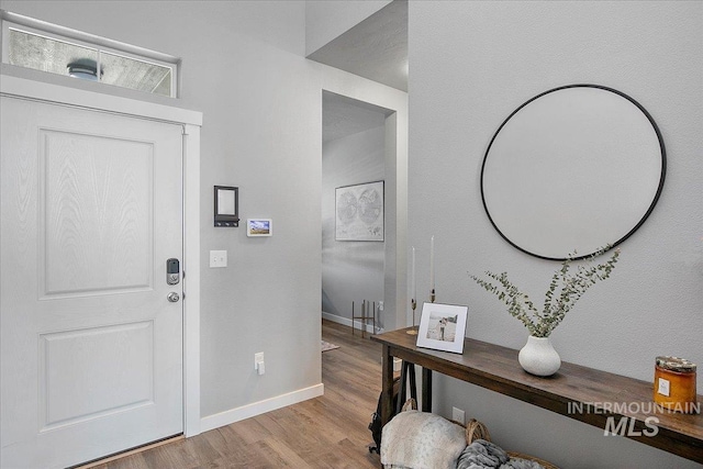 foyer entrance with light wood finished floors and baseboards