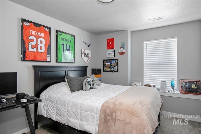 carpeted bedroom with a textured ceiling, visible vents, and baseboards