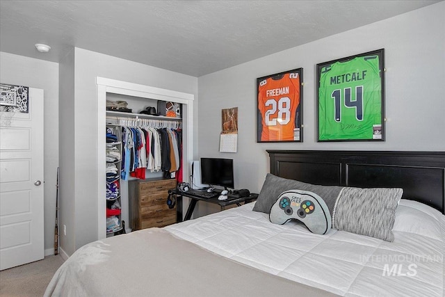 bedroom featuring carpet, a closet, and a textured ceiling