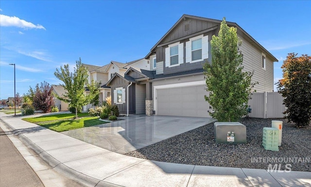 view of front of home featuring board and batten siding, driveway, an attached garage, and fence