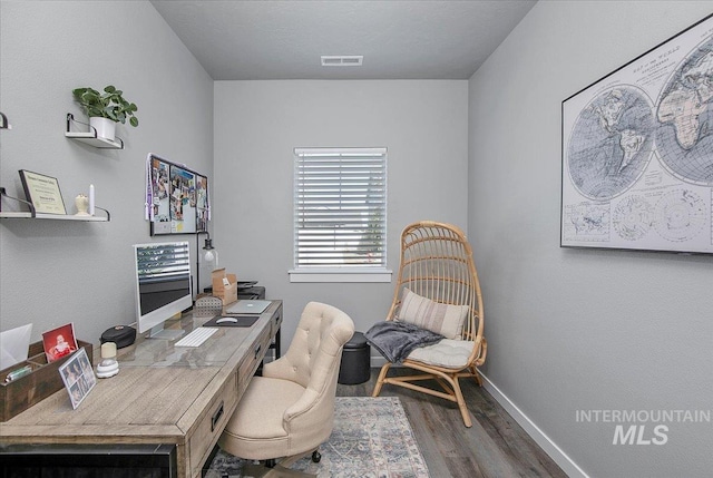 home office with baseboards, visible vents, and wood finished floors