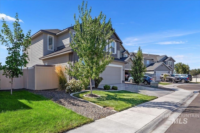 view of front of property with an attached garage, fence, driveway, a residential view, and a front lawn