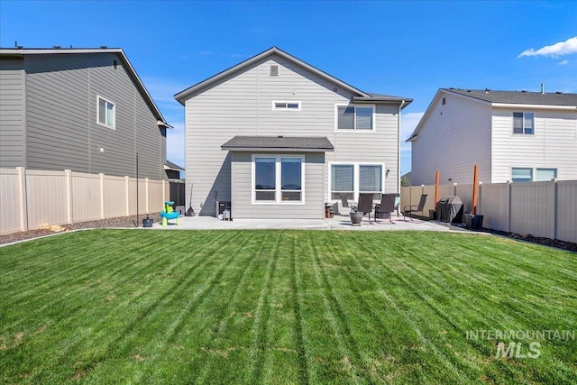 back of house with a patio, a yard, and a fenced backyard