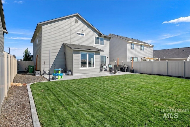 rear view of house featuring a patio area, a lawn, and a fenced backyard