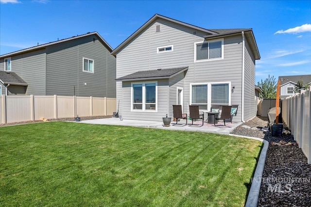 rear view of property with a yard, a fenced backyard, and a patio