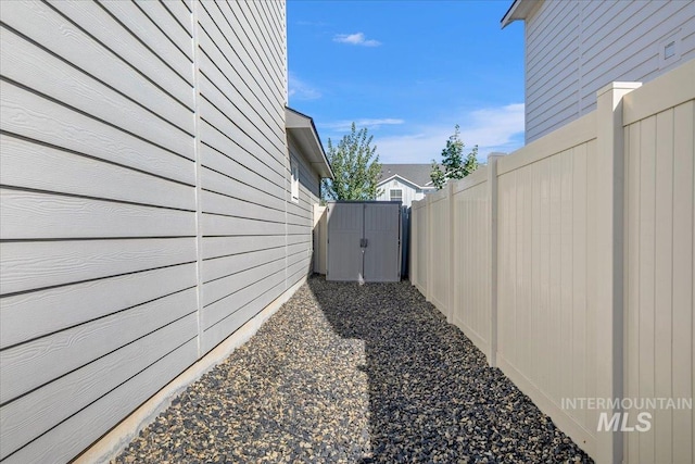 view of property exterior featuring a storage shed, fence, and an outdoor structure