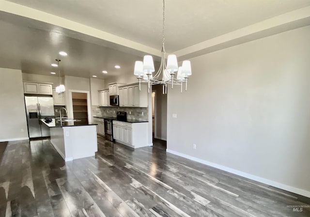 1756 N Hornback Ave, Star, ID 83669 - kitchen with stainless steel appliances, a chandelier, recessed lighting, dark countertops, and tasteful backsplash