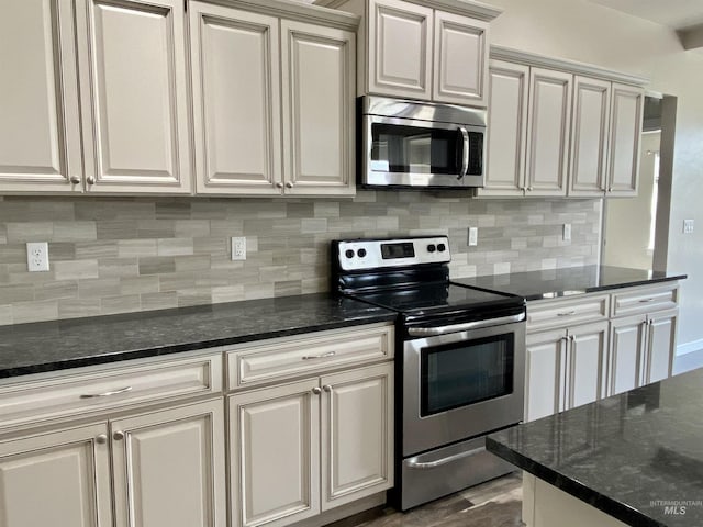 1756 N Hornback Ave, Star, ID 83669 - kitchen featuring appliances with stainless steel finishes, decorative backsplash, dark wood-style flooring, and dark stone counters