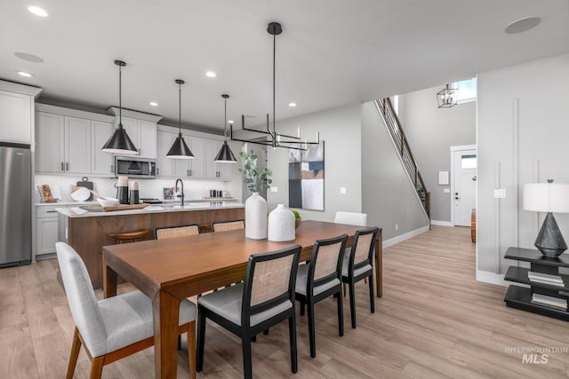 dining space with light hardwood / wood-style floors and sink