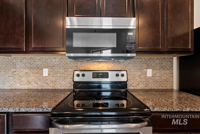 kitchen featuring dark brown cabinetry, dark stone counters, tasteful backsplash, and stainless steel appliances