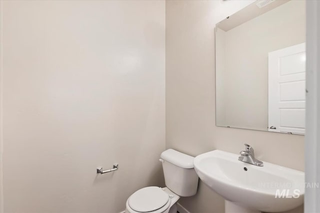 bathroom with a sink, baseboards, and toilet