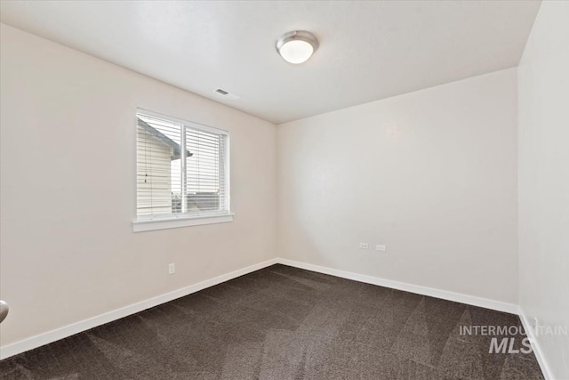 unfurnished room featuring visible vents, baseboards, and dark colored carpet