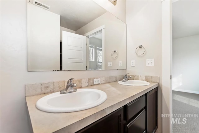 bathroom featuring double vanity, visible vents, and a sink