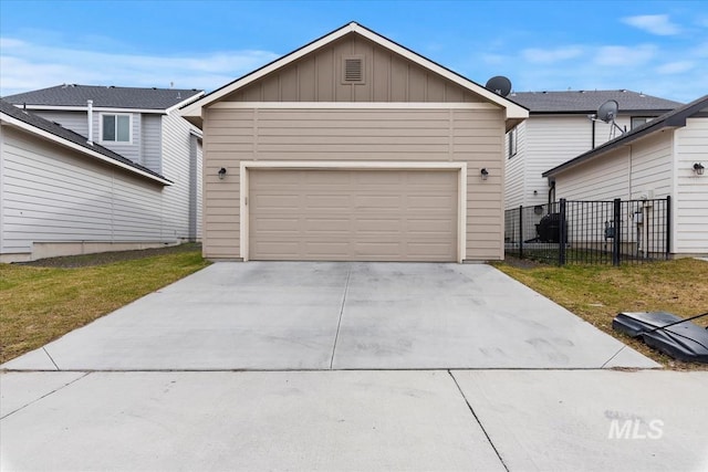 view of front facade featuring a garage, board and batten siding, concrete driveway, and fence