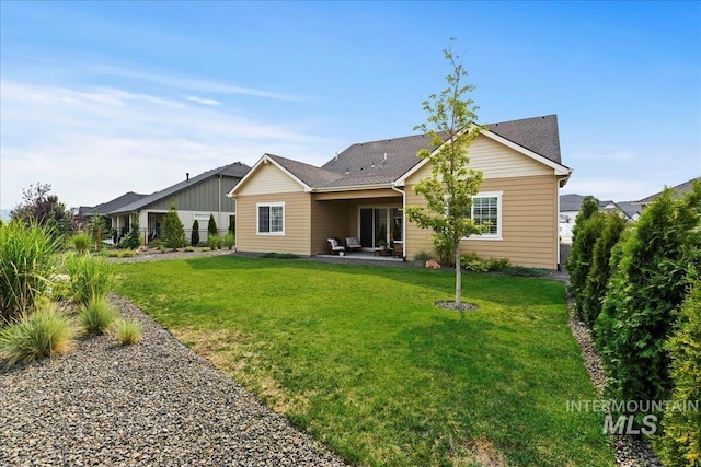 rear view of house featuring a patio area and a lawn