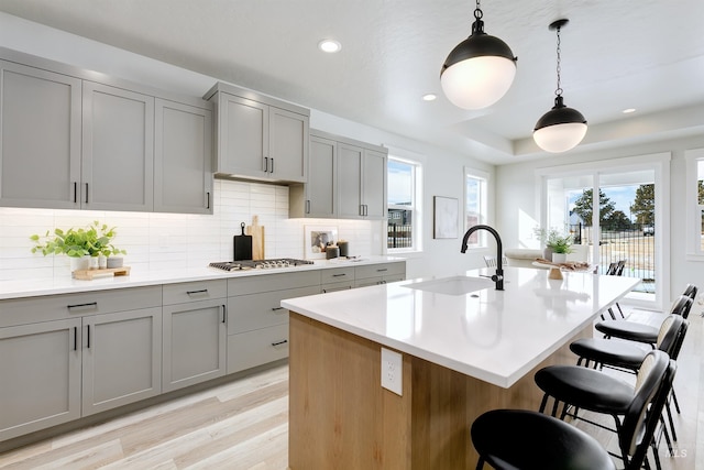 652 N Morning Glory, Eagle, ID 83616 - kitchen with light countertops, tasteful backsplash, a breakfast bar area, gray cabinets, and a sink