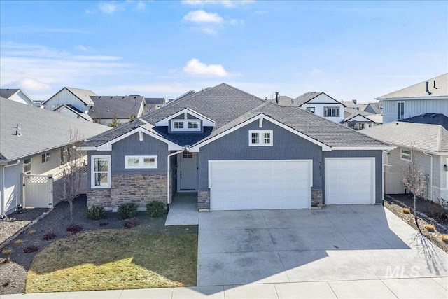 view of front of home featuring stone siding, driveway, and fence