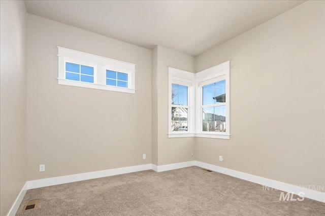 carpeted empty room featuring visible vents and baseboards