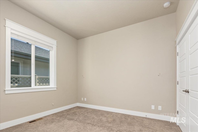 carpeted empty room with visible vents and baseboards