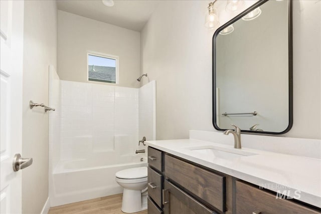 bathroom with toilet, tub / shower combination, wood finished floors, and vanity