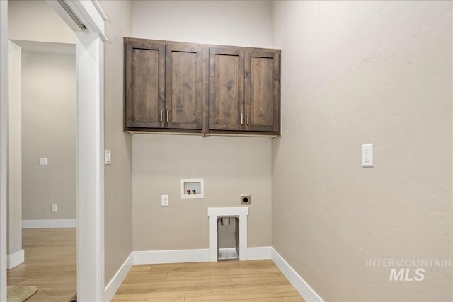 laundry area with cabinet space, baseboards, hookup for a washing machine, hookup for an electric dryer, and light wood-type flooring